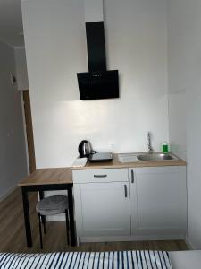 eine Küche mit einem Waschbecken und einem Holztisch in der Unterkunft Aparthotel Dworzec in Elblag