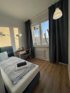 a bedroom with a bed and a desk and a window at Aparthotel Dworzec in Elblag