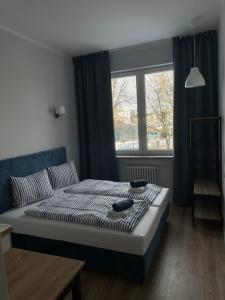 a bedroom with a bed and a window at Aparthotel Dworzec in Elblag +5 photos