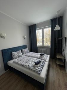 a bedroom with a bed with two shoes on it at Aparthotel Dworzec in Elblag