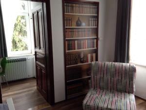 a book shelf with a chair in a living room at Apartments My Zagreb in Zagreb