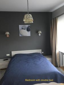a bedroom with a bed with a blue comforter at Roman in Druskininkai +24 photos