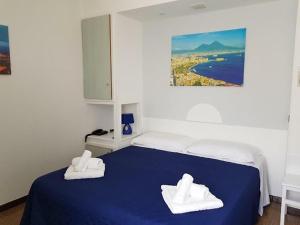 una camera da letto con un letto blu e asciugamani di Hotel La Plancia a Otranto