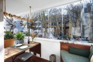 a balcony with a table and a large window at Cozy Beach House São Pedro Estoril in São Pedro do Estoril