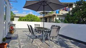 een tafel en stoelen met een parasol op een patio bij Chez Bibi 
