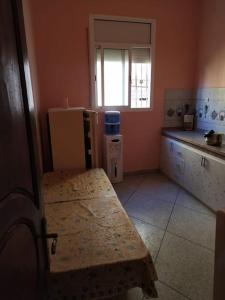 a kitchen with a counter and a refrigerator and a window at Logement entier appartement in Erfoud