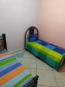 1 dormitorio con 2 camas con rayas coloridas en Logement entier appartement, en Erfoud