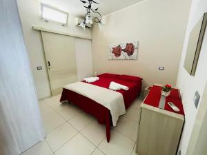 トッレ・ラピッロにあるSea Apartmentのベッドルーム1室(赤と白のベッド1台付)
