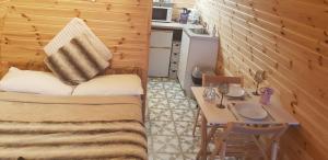 a small room with a table and a bed and a kitchen at Loughmourne Glamping Pod 