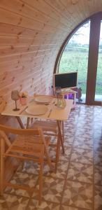 a wooden table and chairs in a room with a window at Loughmourne Glamping Pod 