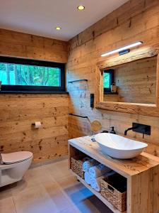 uma casa de banho com um lavatório branco e um WC. em Forest Garden Romance 