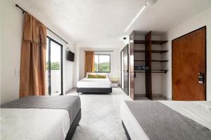 a bedroom with two beds and a large window at Hotel Balcones del Estadio in Medellín