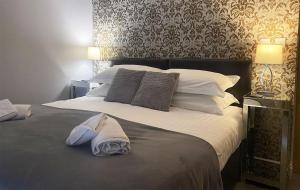 ein Schlafzimmer mit einem großen Bett mit weißen Laken und Kissen in der Unterkunft Mill House Cottage, Fishing Park, Brampton, Nr Carlisle in Brampton