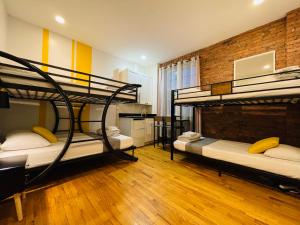 a room with three bunk beds and a brick wall at Hotel and the City, Empire State Building in New York +139 photos