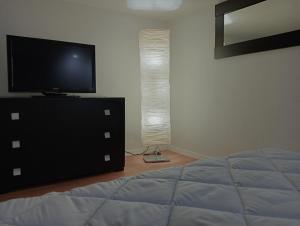 a bedroom with a bed and a television on a dresser at Maison Damas in Barletta