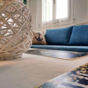 a living room with a blue couch and a rug at Zenios Andros-Cycladic house overlooking Batsi bay in Batsi