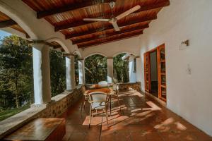 porche con ventilador de techo, mesa y sillas en Hotel Planeta Sano, en Manuel Antonio