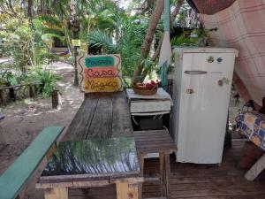 a wooden table with a stove and a refrigerator at Camping Casa Mágica-Taipu de Fora in Barra Grande
