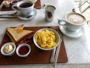 a breakfast plate with eggs and toast and a cup of coffee at B&B - Private rooms 2 in Tirana