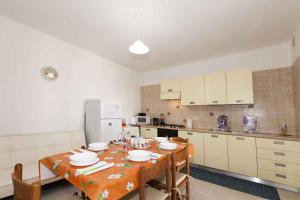 Il comprend une cuisine équipée d'une table, de chaises et d'un réfrigérateur. dans l'établissement Holiday home in Quartu Sant'Elena 36783, à Santa Luria