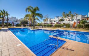 El RomeroにあるAwesome Apartment In Alhama De Murcia With 3 Bedrooms, Wifi And Outdoor Swimming Poolのヤシの木と家がある大型スイミングプール