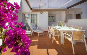 El RomeroにあるAwesome Apartment In Alhama De Murcia With 3 Bedrooms, Wifi And Outdoor Swimming Poolの紫の花が咲くダイニングルーム