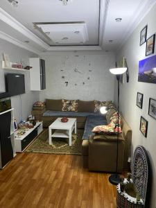 a living room with a couch and a clock on the wall at dar leena in Essaouira +25 photos