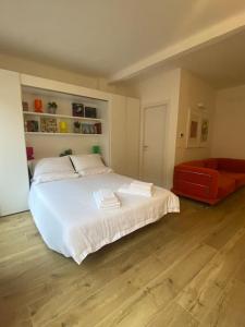 ボローニャにあるAppartamento San Feliceのベッドルーム(白い大型ベッド1台、赤いソファ付)