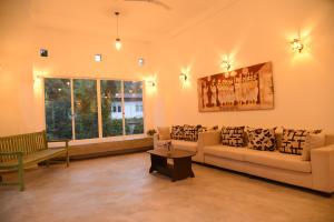 uma sala de estar com um sofá e uma mesa em Everdew Kandy em Kandy