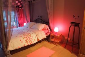 Schlafzimmer mit einem Bett mit roter Lampe in der Unterkunft La Grange de David - Access-i in Hamoir