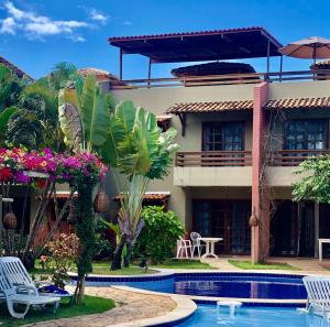 a resort with a swimming pool in front of a building at Resort Pipa Casa20 - Triplex maravilhoso in Pipa