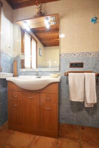 ein Bad mit einem Waschbecken und einem Spiegel in der Unterkunft La Casita de Chocolate in Cambados