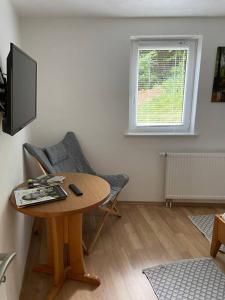 a living room with a table and a television at Naturpanorama in Gleiszellen-Gleishorbach