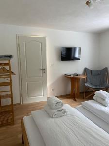 a room with two beds and a chair and a door at Naturpanorama in Gleiszellen-Gleishorbach