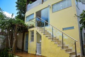una casa amarilla con una escalera delante de ella en Quitenetes-Morro de Sao Paulo, Bahia ate para 2 adultos e 2 criancas en Morro de São Paulo