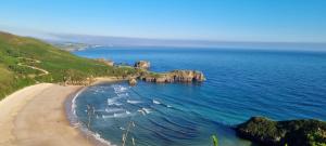 an aerial view of a beach with rocks in the ocean at Apartamentos Les Texuques II in Nueva de Llanes +14 photos