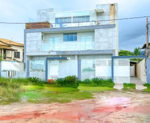 a house with white garage doors in front of it at Casa c WiFi e vista para o mar-Barra de São João RJ in Casimiro de Abreu