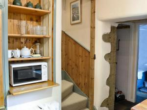 a tiny house with a microwave on a staircase at Langcliffe Lock Cottage in Stainforth