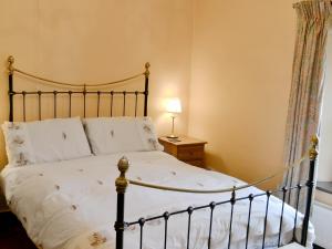 a bedroom with a bed with a wrought iron bed frame at Langcliffe Lock Cottage in Stainforth