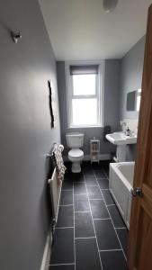STAY - at Southport Holiday Home - sleeps 6 في ساوثبورت: حمام مع مرحاض ومغسلة وحوض استحمام
