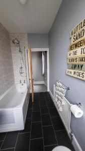La salle de bains est pourvue d'une baignoire, d'un lavabo et de toilettes. dans l'établissement STAY - at Southport Holiday Home - sleeps 6, à Southport