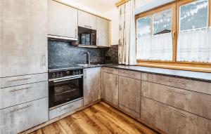 a kitchen with stainless steel appliances and wooden floors at Amazing Apartment In Grossarl With 2 Bedrooms And Wifi in Grossarl