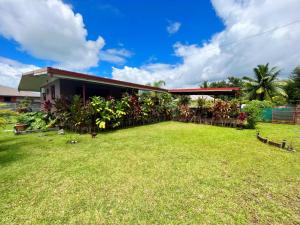 una casa con césped delante en TAHITI - Fare Matavai Hoe, en Taravao