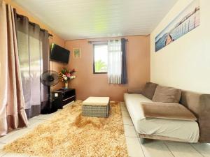 sala de estar con sofá y alfombra en TAHITI - Fare Matavai Hoe en Taravao