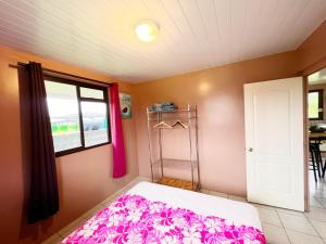 een slaapkamer met een bed en een raam bij TAHITI - Fare Matavai Hoe in Taravao