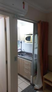 a kitchen with a sink and a microwave at diRoma Rio Quente - Para Voce se Sentir em Casa :D in Rio Quente