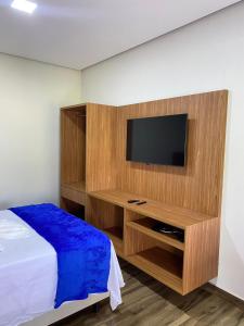 a bedroom with a bed and a tv on a wall at Chalés Vista da Serra in Piauí