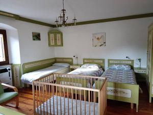 ein Schlafzimmer mit 2 Betten und einem Kinderbett in der Unterkunft Dolomia in Villagrande
