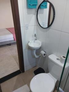 a bathroom with a toilet and a sink and a mirror at Sobrado Flor de Maio in Milho Verde