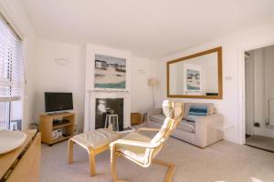 uma sala de estar com um sofá e uma cadeira em The Bolthole em Aldeburgh